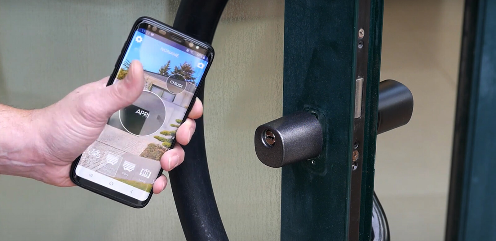Chave tradicional e telemóvel comparados diante de uma porta